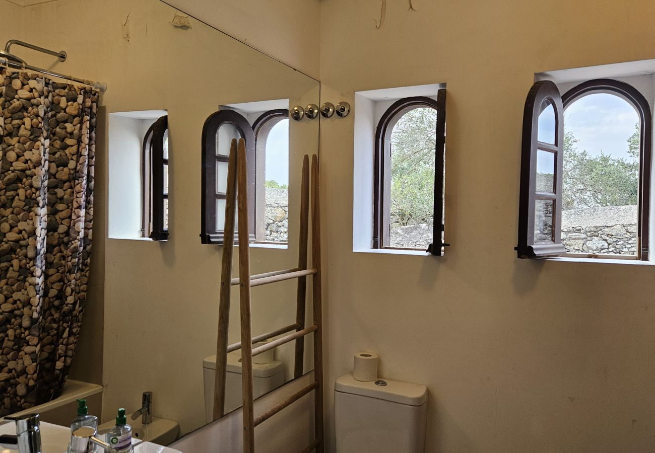 Casa de banho espaçosa, com luz natural e vista relaxante para o jardim verdejante. 