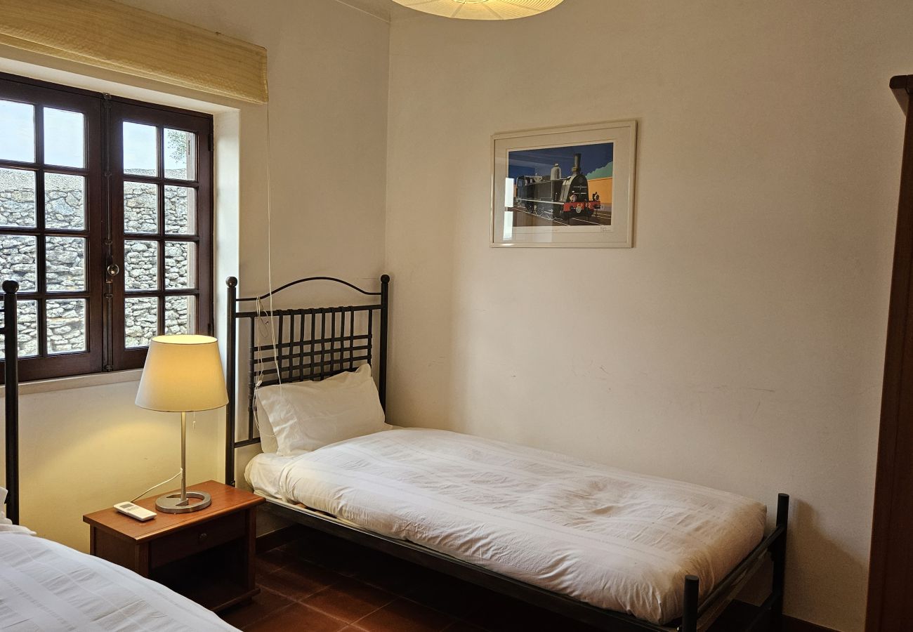 Quarto espaçoso com duas camas separadas, decoração acolhedora e vista relaxante. 
