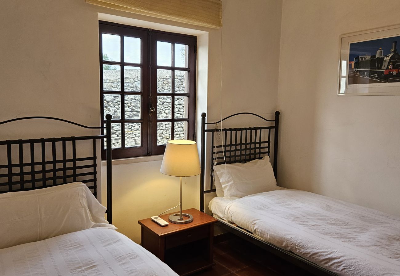 Quarto espaçoso com duas camas separadas, decoração acolhedora e vista relaxante.