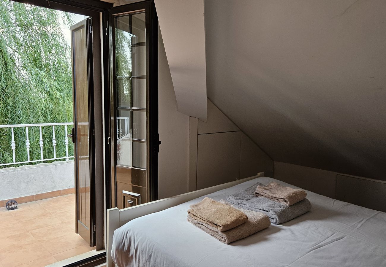 Quarto aconchegante com cama de casal, varanda aberta e vista para o jardim verdejante.
