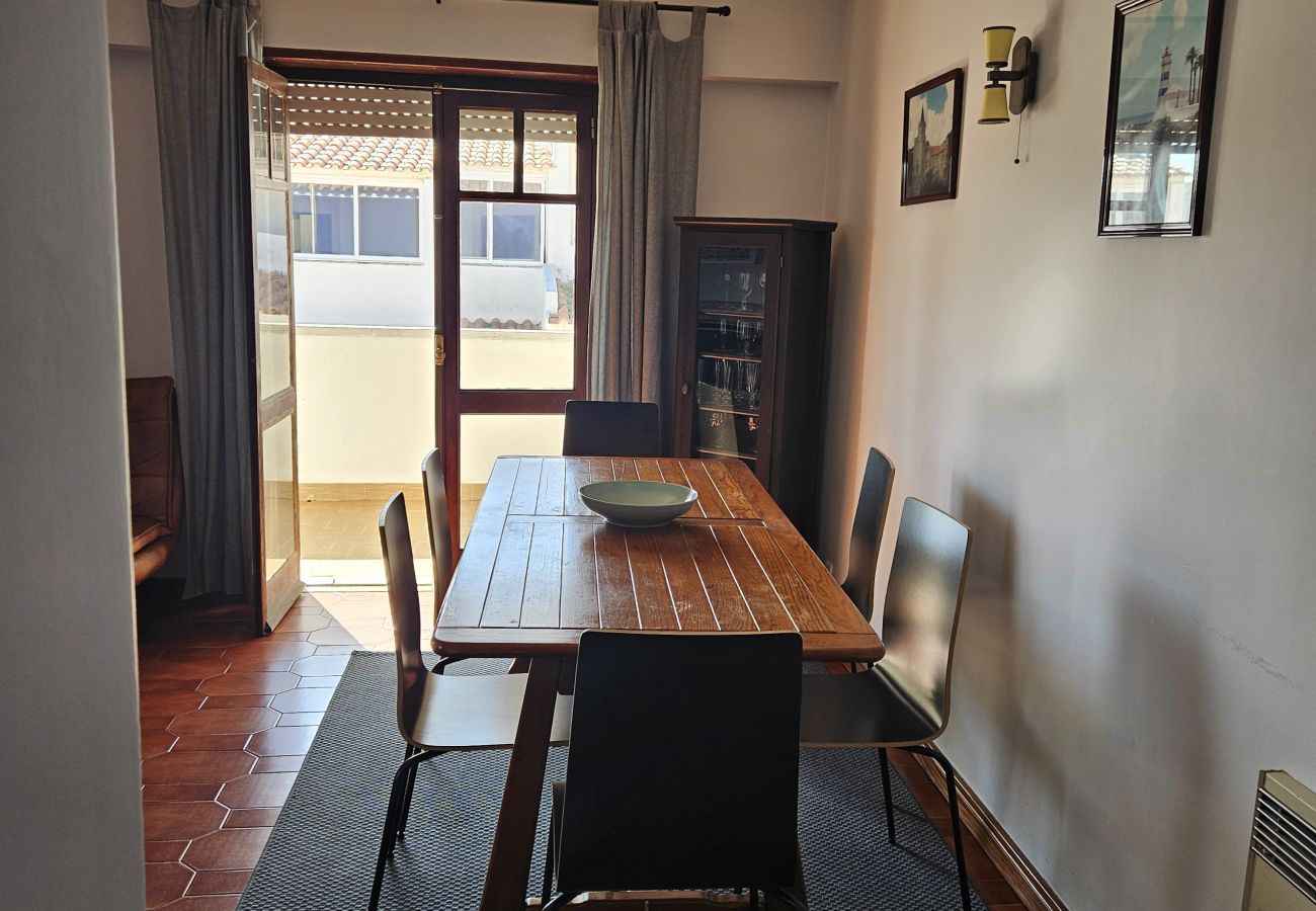 Mesa de jantar rústica com cadeiras pretas, em um ambiente bem iluminado.
