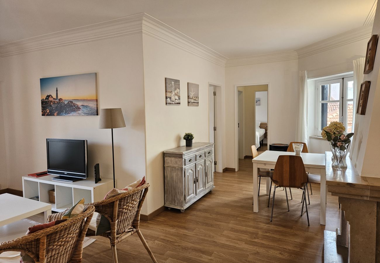 Sala com sofá aconchegante, mesa de jantar de madeira e decoração moderna. 