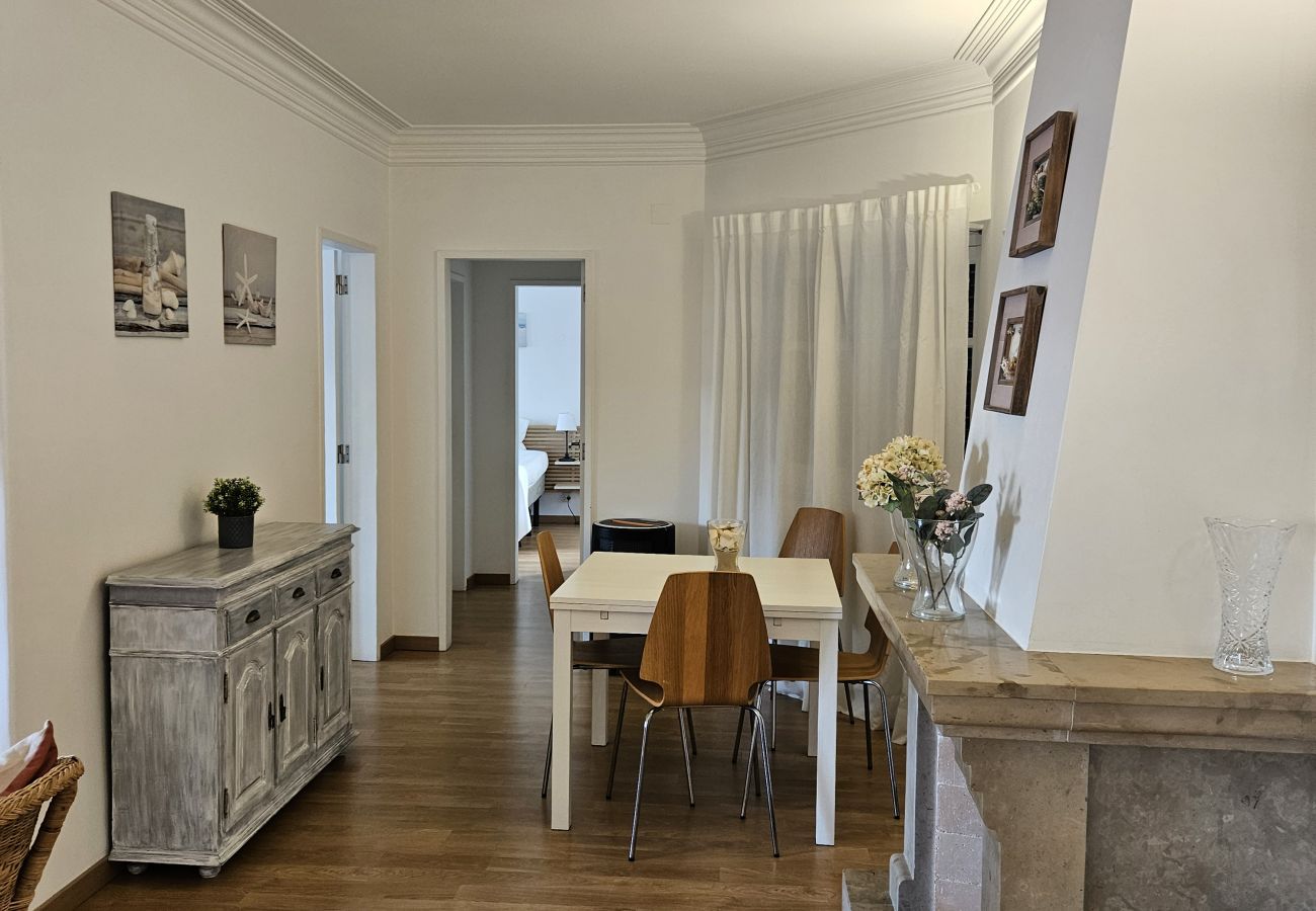 Sala ampla com sofá, mesa de café e janelas grandes com luz natural.