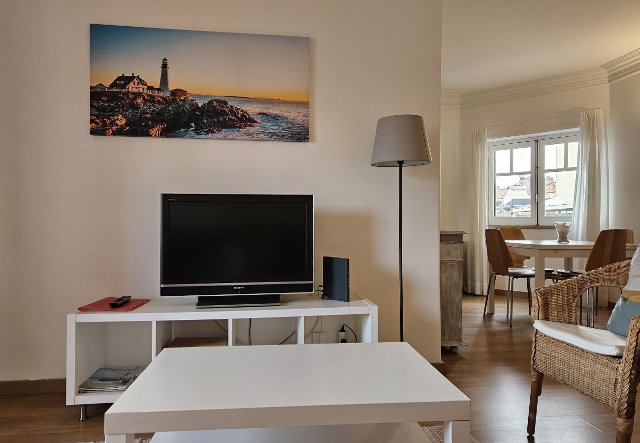 Sala decorada com sofá confortável, TV e iluminação aconchegante. 