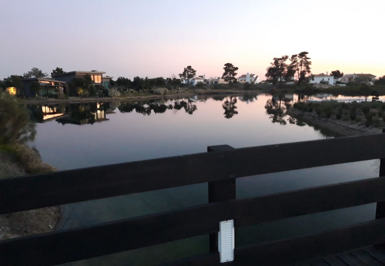 Lago tranquilo refletindo árvores e o céu ao anoitecer na região de Troia.
