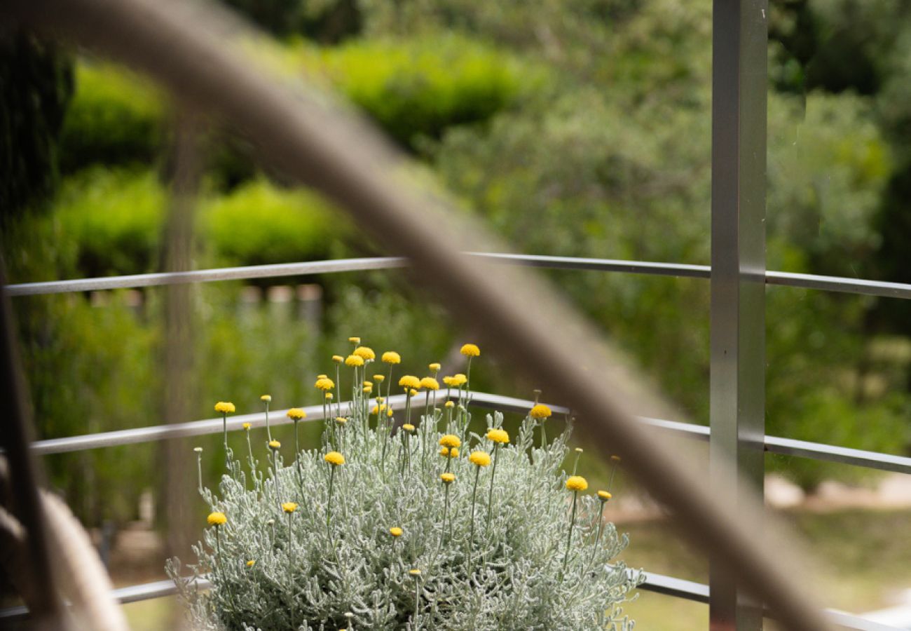 Flores decorativas no terraço com vista para o jardim verdejante na Pool Beach & Golf Troia.