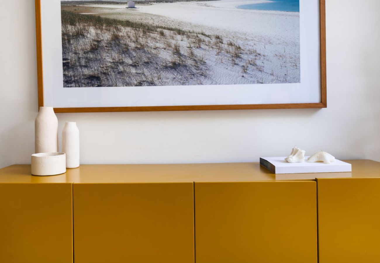 Armário amarelo com decoração minimalista e obra de arte na Pool Beach & Golf Troia.
