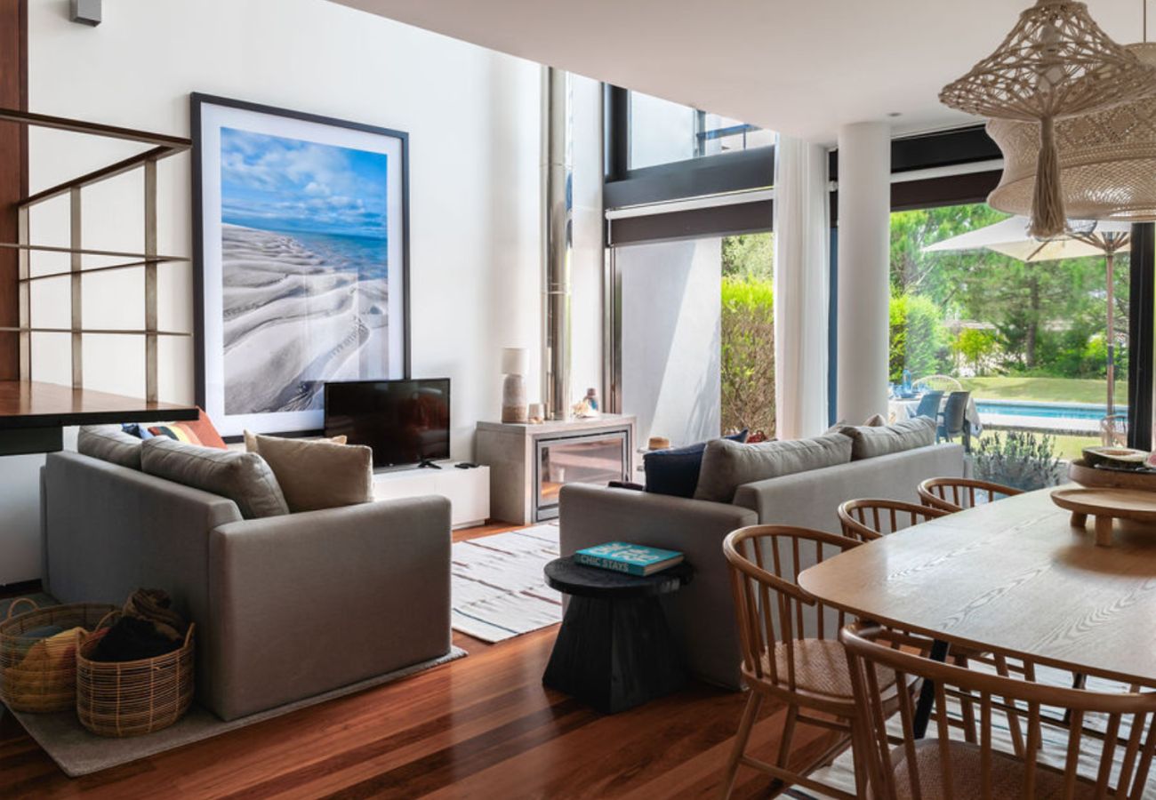 Sala de estar espaçosa com sofás confortáveis e vista para o jardim na Pool Beach & Golf Troia.