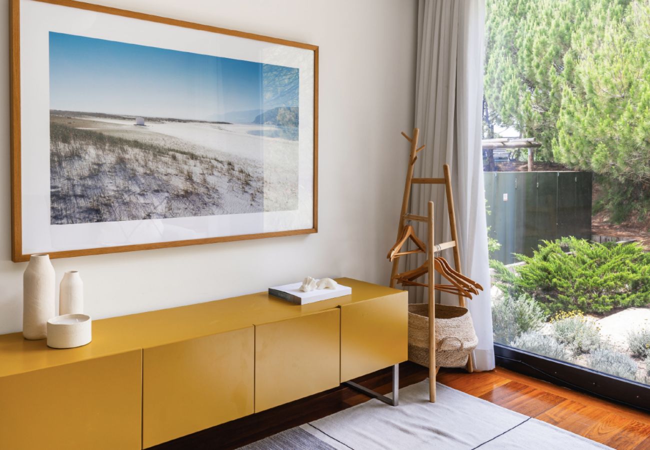 Armário amarelo com decoração minimalista e obra de arte na Pool Beach & Golf Troia.