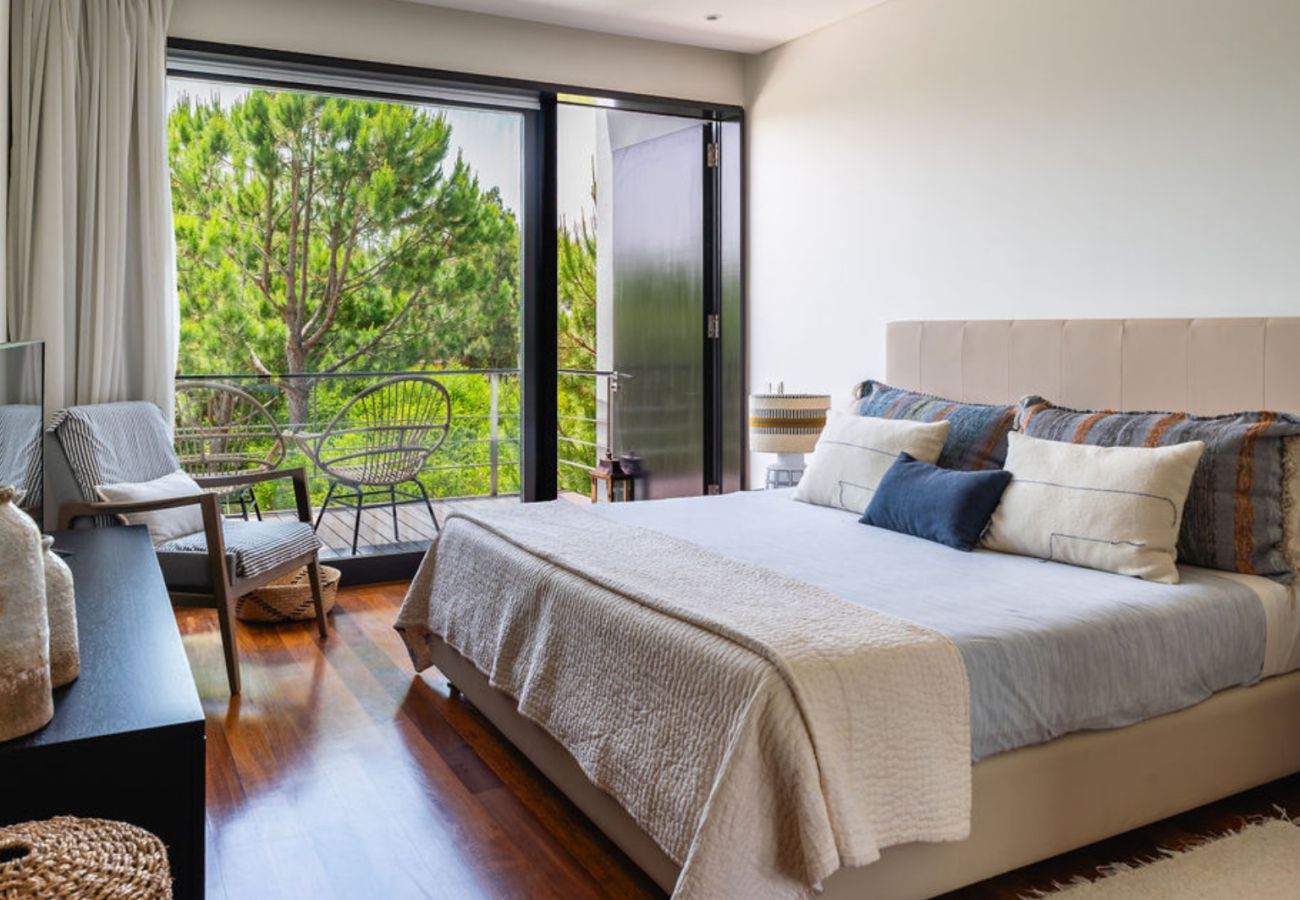 Quarto com cama confortável, decoração clean e vista para o jardim na Pool Beach & Golf Troia.