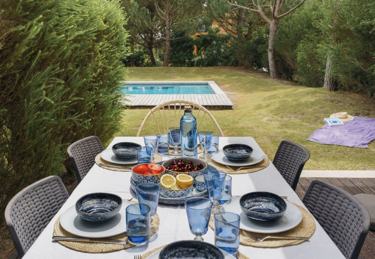 Mesa ao ar livre elegantemente decorada com vista para o jardim na Pool Beach & Golf Troia.