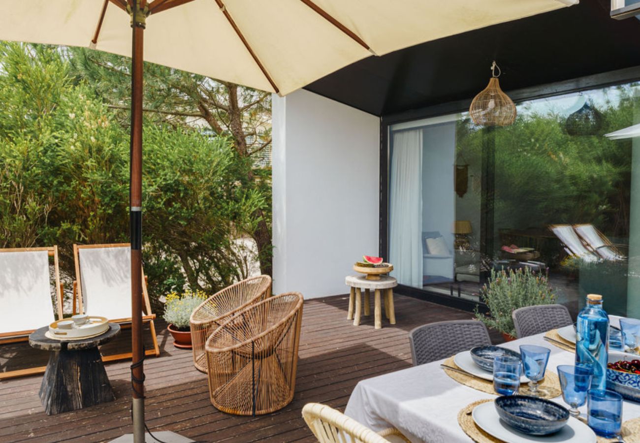 Mesa ao ar livre no terraço com vista para o jardim na Pool Beach & Golf Troia.