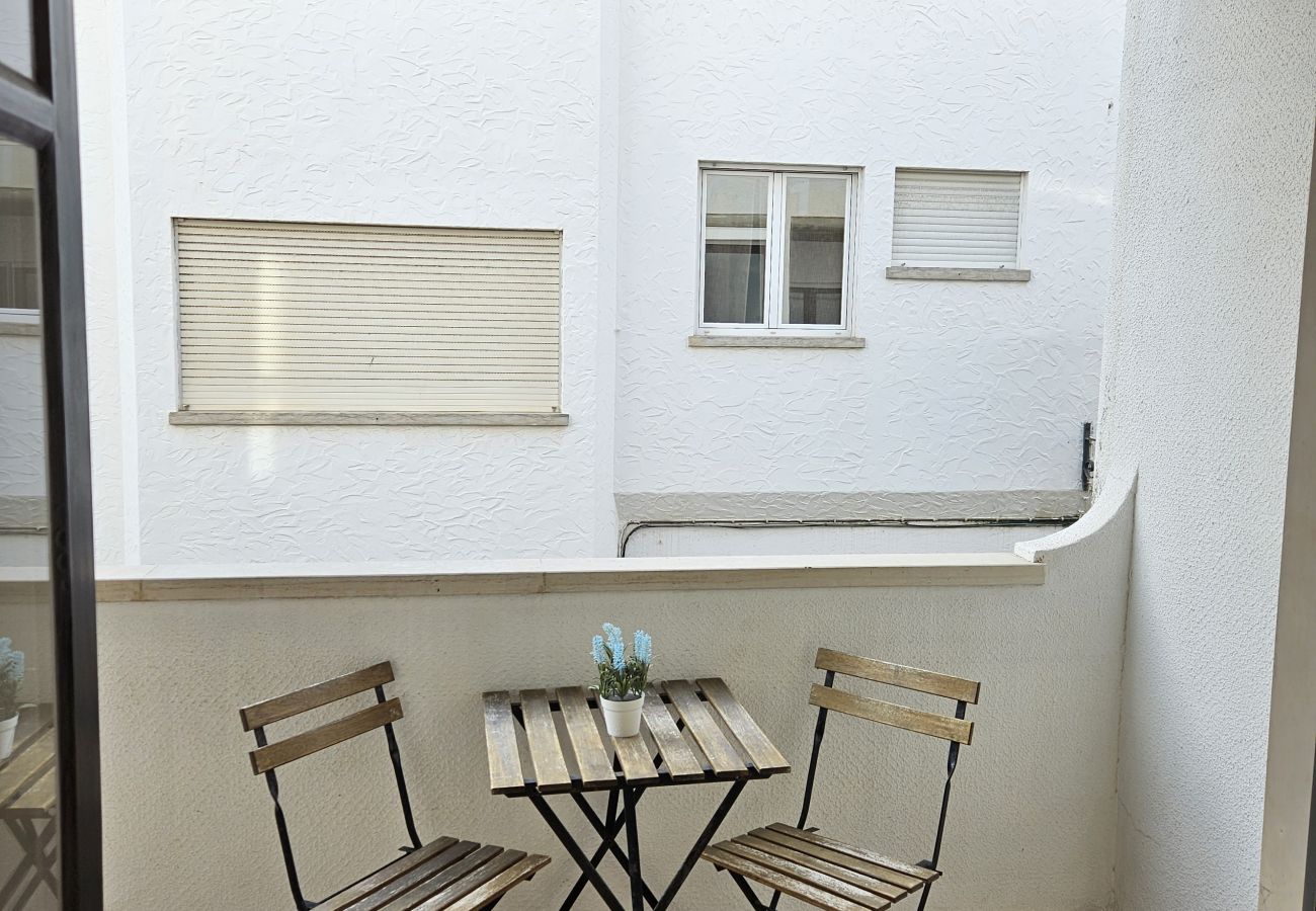 Pequena varanda com mesa e cadeiras, ideal para um café da manhã ao ar livre.