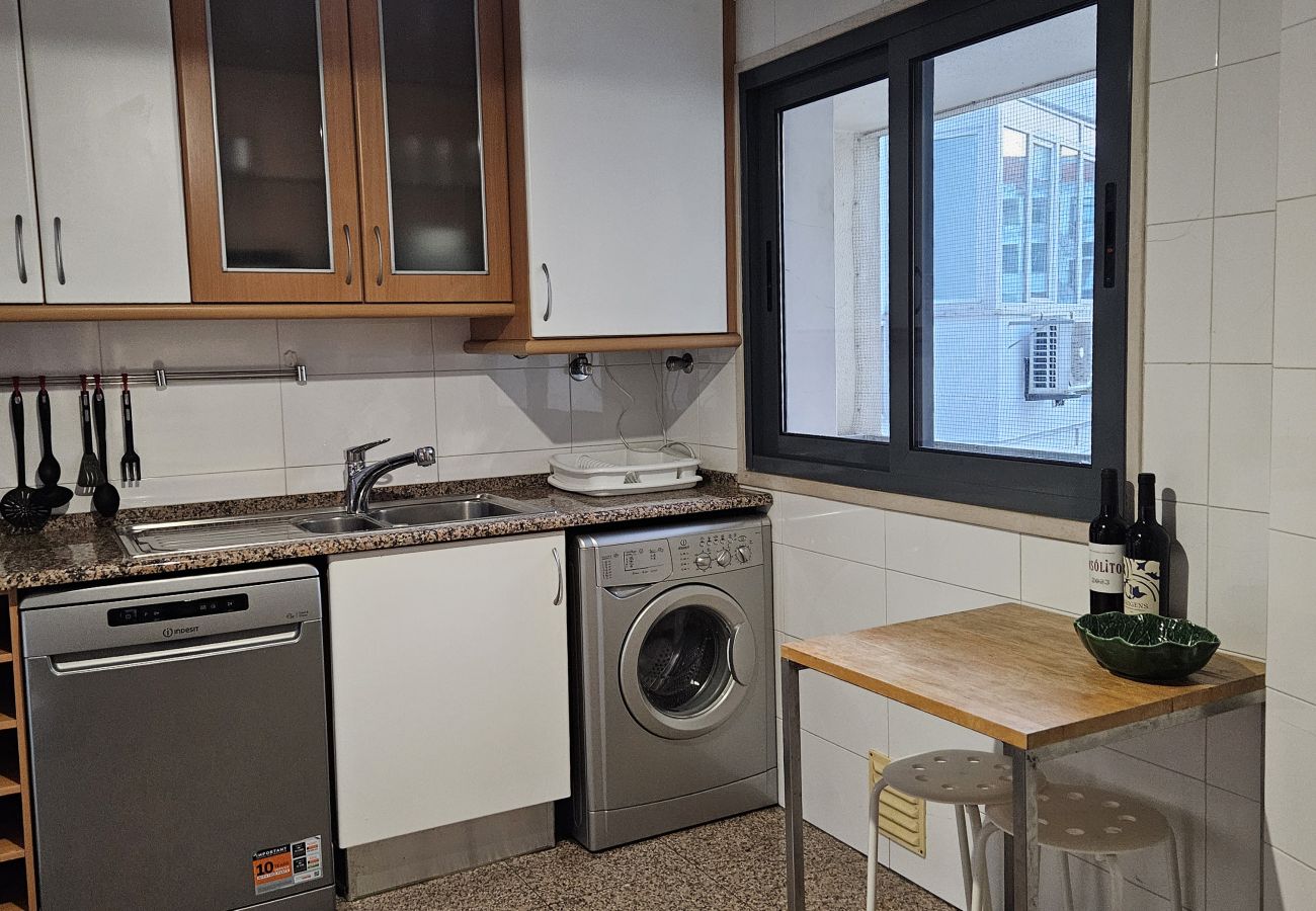 Cozinha com armários de madeira, eletrodomésticos modernos e ampla bancada.