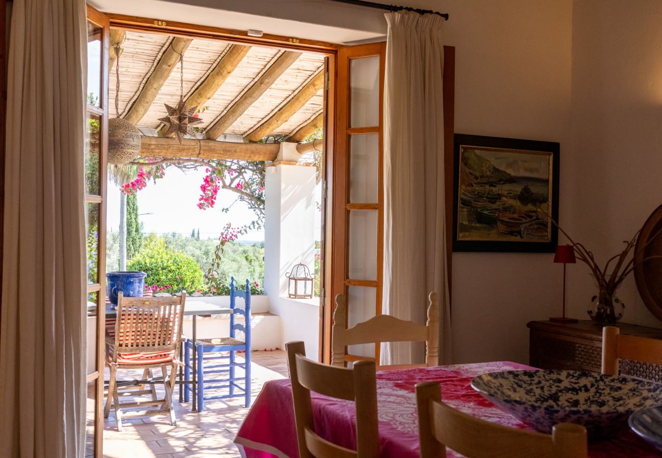 Sala de estar espaçosa com lareira, sofás vermelhos e decoração rústica em Almancil.
