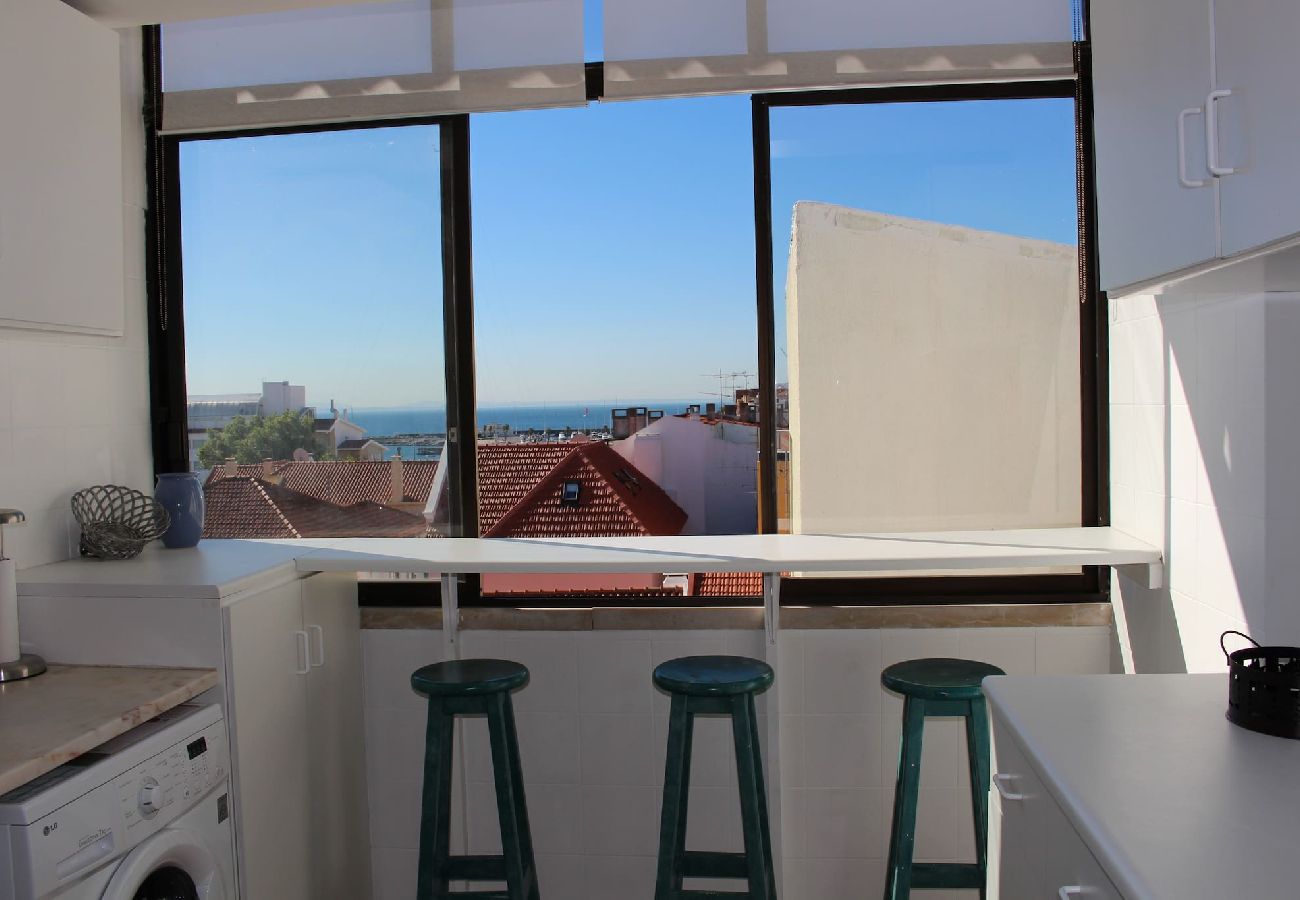Bright kitchen with worktop and stools, overlooking the city's rooftops. 