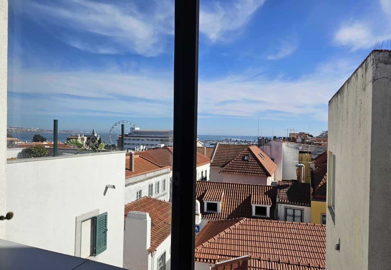 Large windows reveal the city's rooftops and blue skyline. 