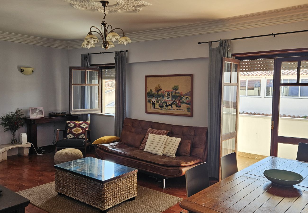 Bright living room with leather sofa, coffee table and access to the balcony. 