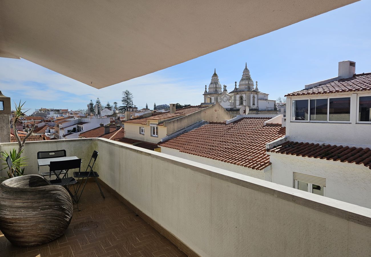 Spacious balcony overlooking the rooftops and a church dome in the background.