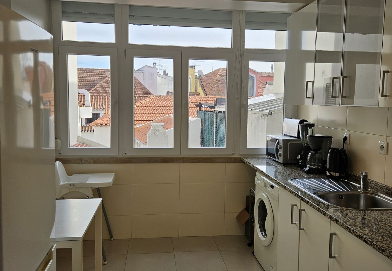 Fitted kitchen with large windows and city views. 