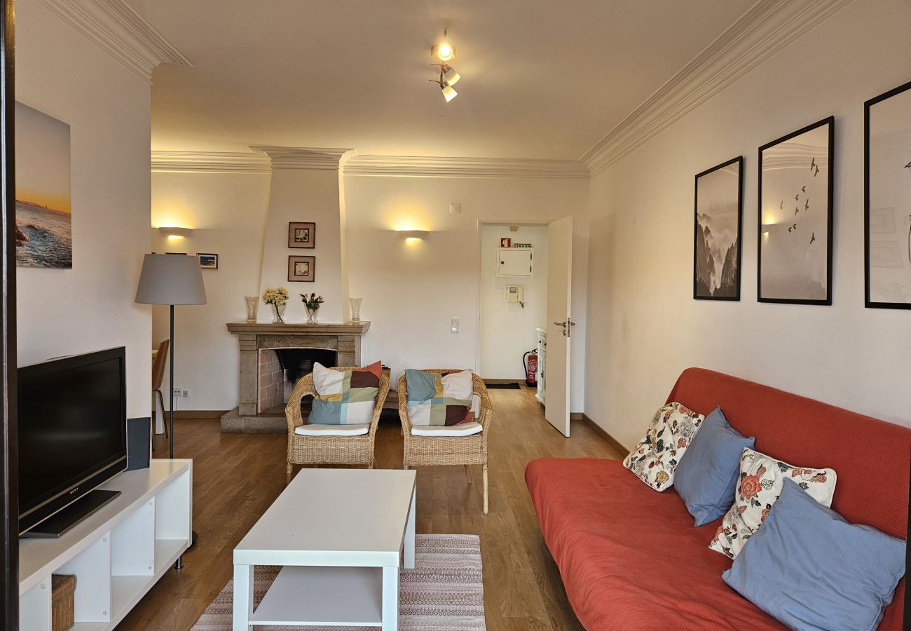 Living room with a cozy sofa, wooden dining table, and modern decor. 