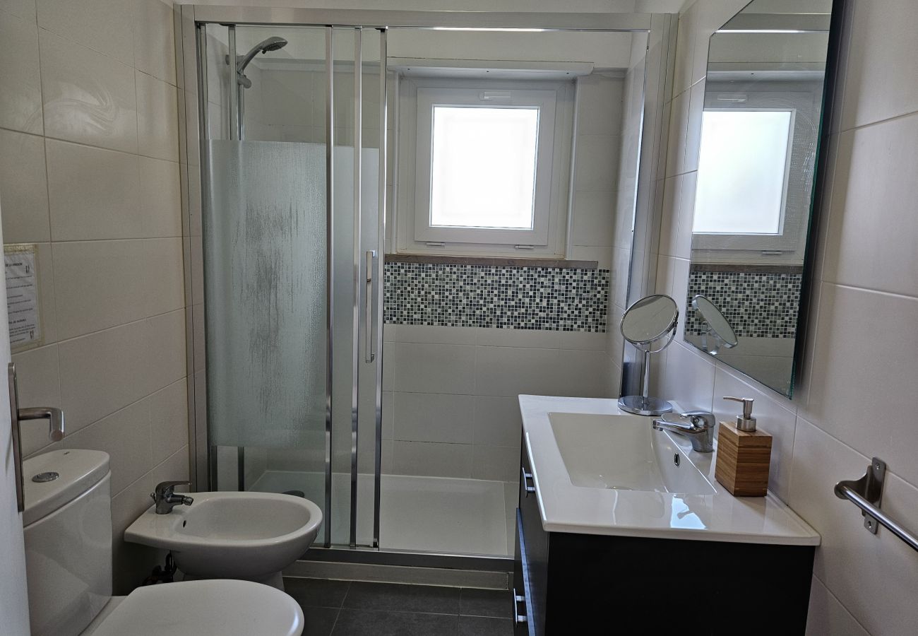 Spacious bathroom with a bathtub, large mirror, and pleasant natural light. 