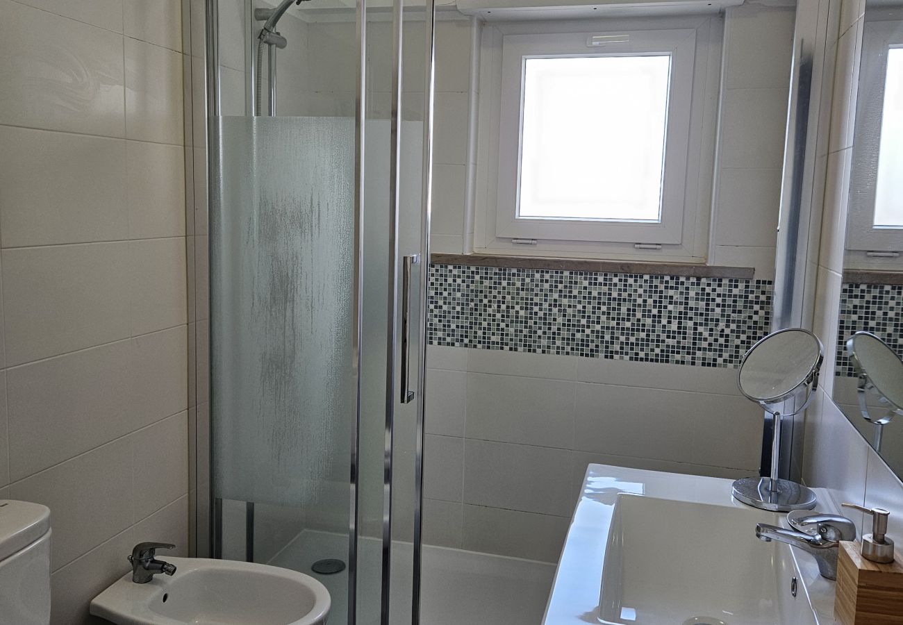 Spacious bathroom with a bathtub, large mirror, and pleasant natural light.