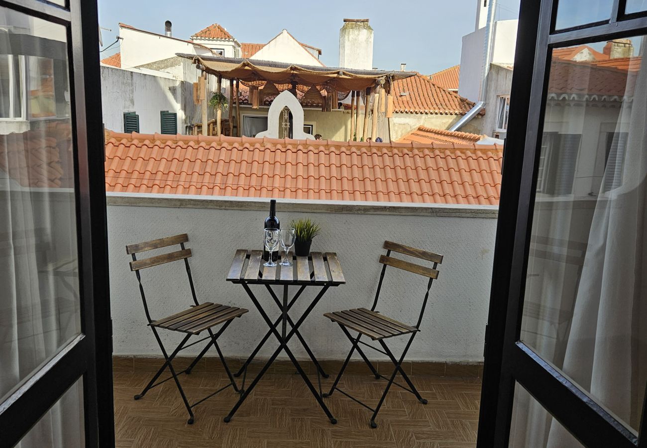 Cozy balcony with table and chairs for relaxing moments. 