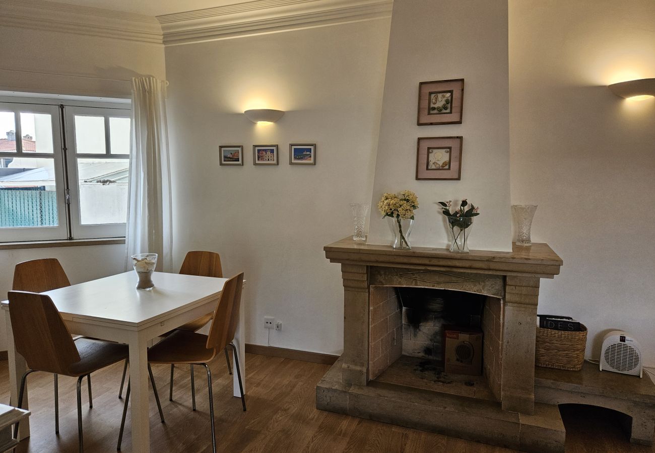 Bright living room with an elegant dining table and large windows with an outdoor view.. 