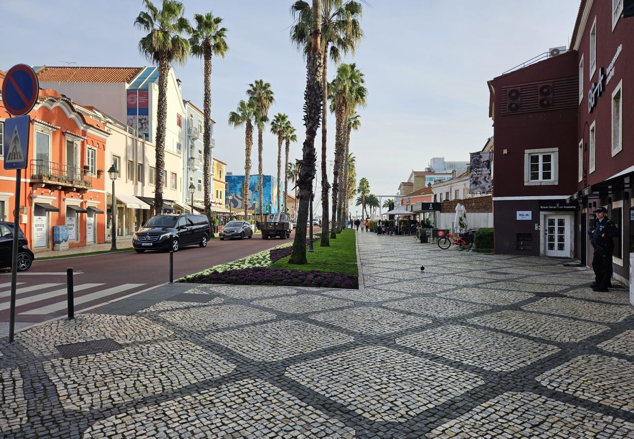 Bustling avenue in Cascais' historic center, with shops, cafés, and traditional architecture. 