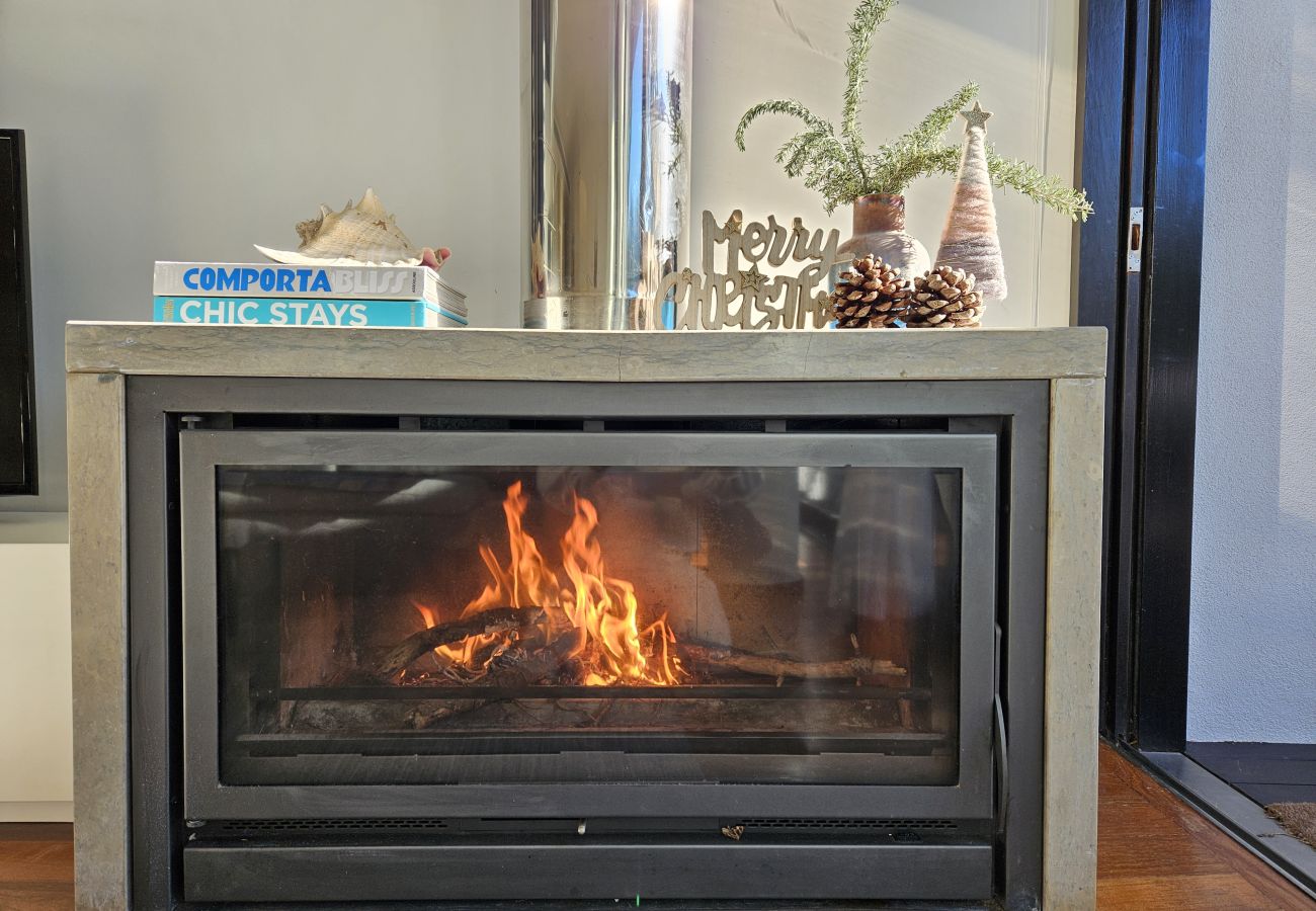 Lit fireplace with warm decor, creating a relaxing atmosphere at Pool Beach & Golf Troia.