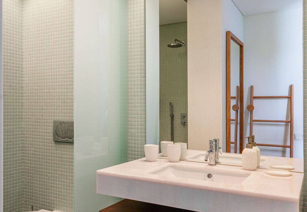 Modern bathroom with light countertop and minimalist decor at Pool Beach & Golf Troia.