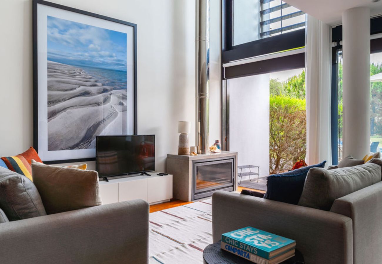 Comfortable living room with sofas, TV, and access to the terrace with natural light at Pool Beach & Golf Troia.