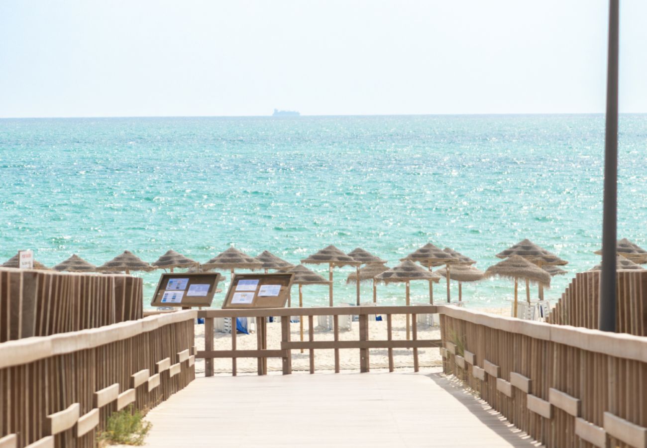Wooden boardwalk leading directly to the white sandy beach in Troia at Pool Beach & Golf Troia.