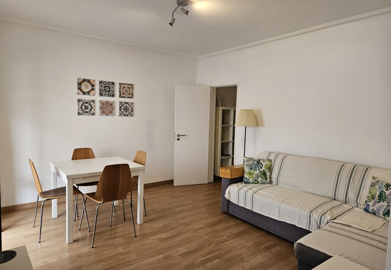 Cozy living room with a sofa and decorative tile paintings.