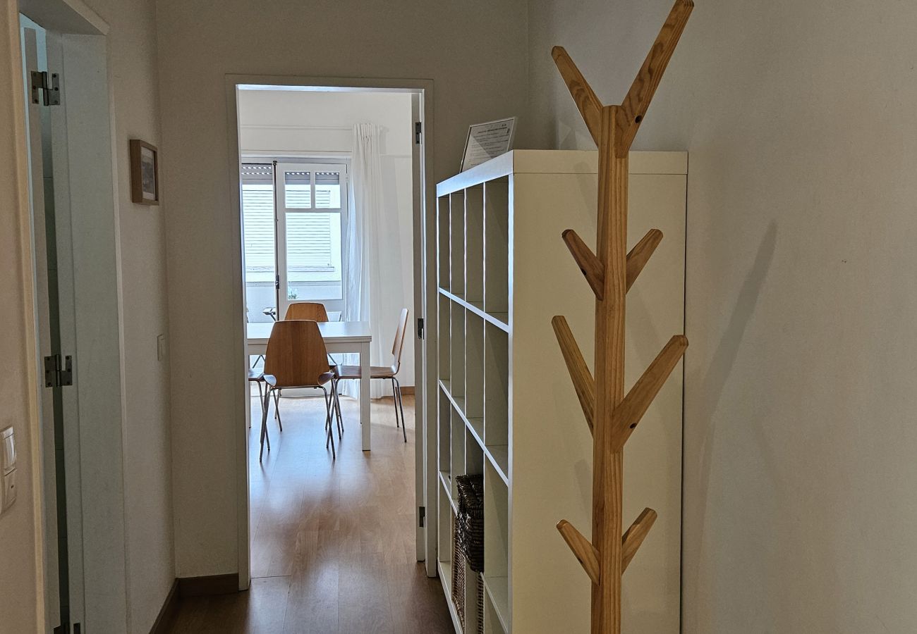 Cozy hallway with wooden flooring, modern coat rack, and access to the dining area at Bolina 1 Historic Center Cascais.