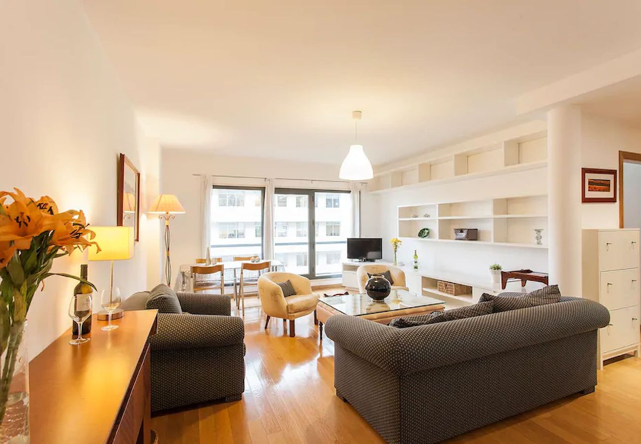 Living room decorated in neutral tones, featuring a comfortable sofa, coffee table, and TV.