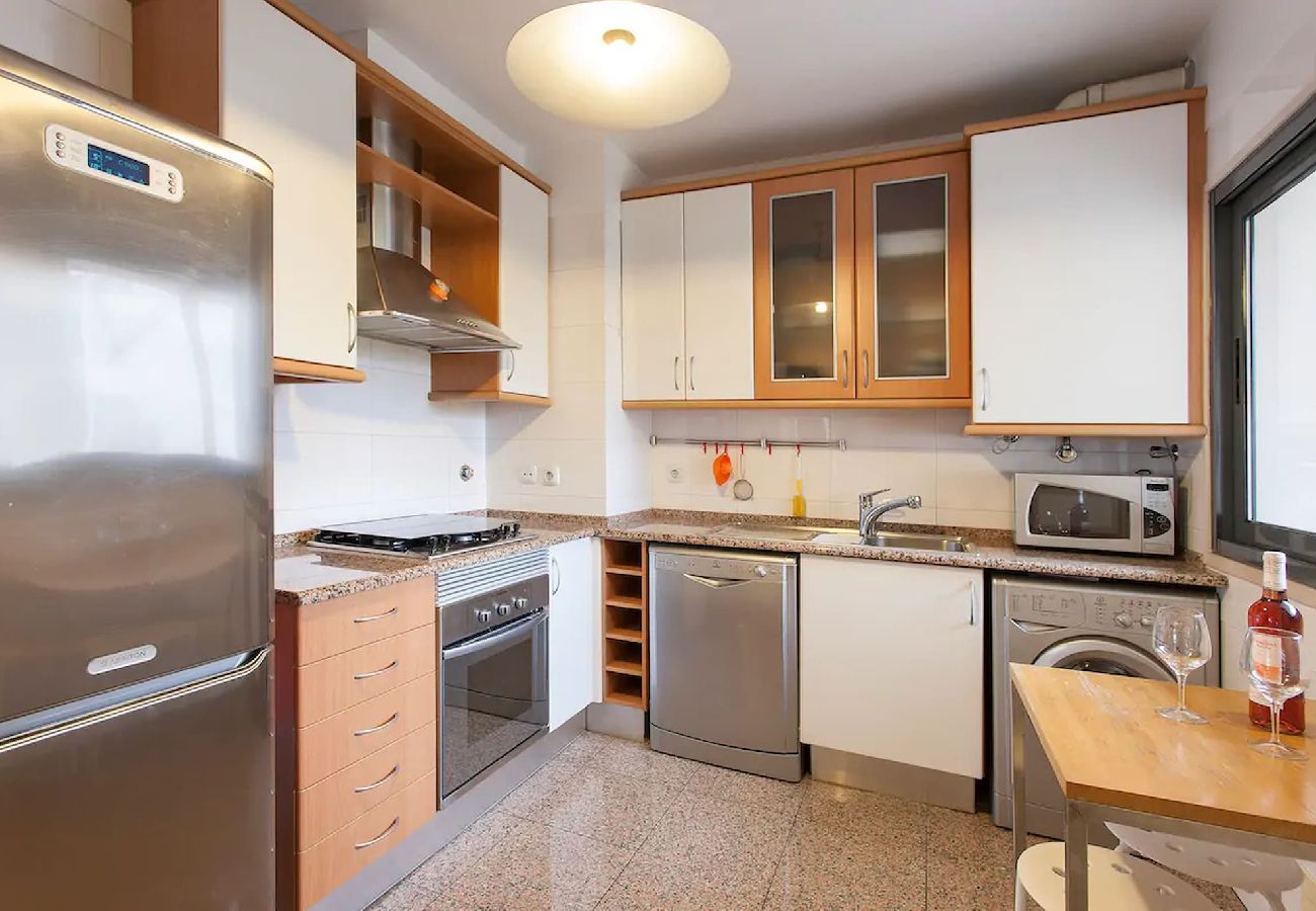 Fully equipped kitchen with modern appliances, a spacious countertop, and essential utensils.