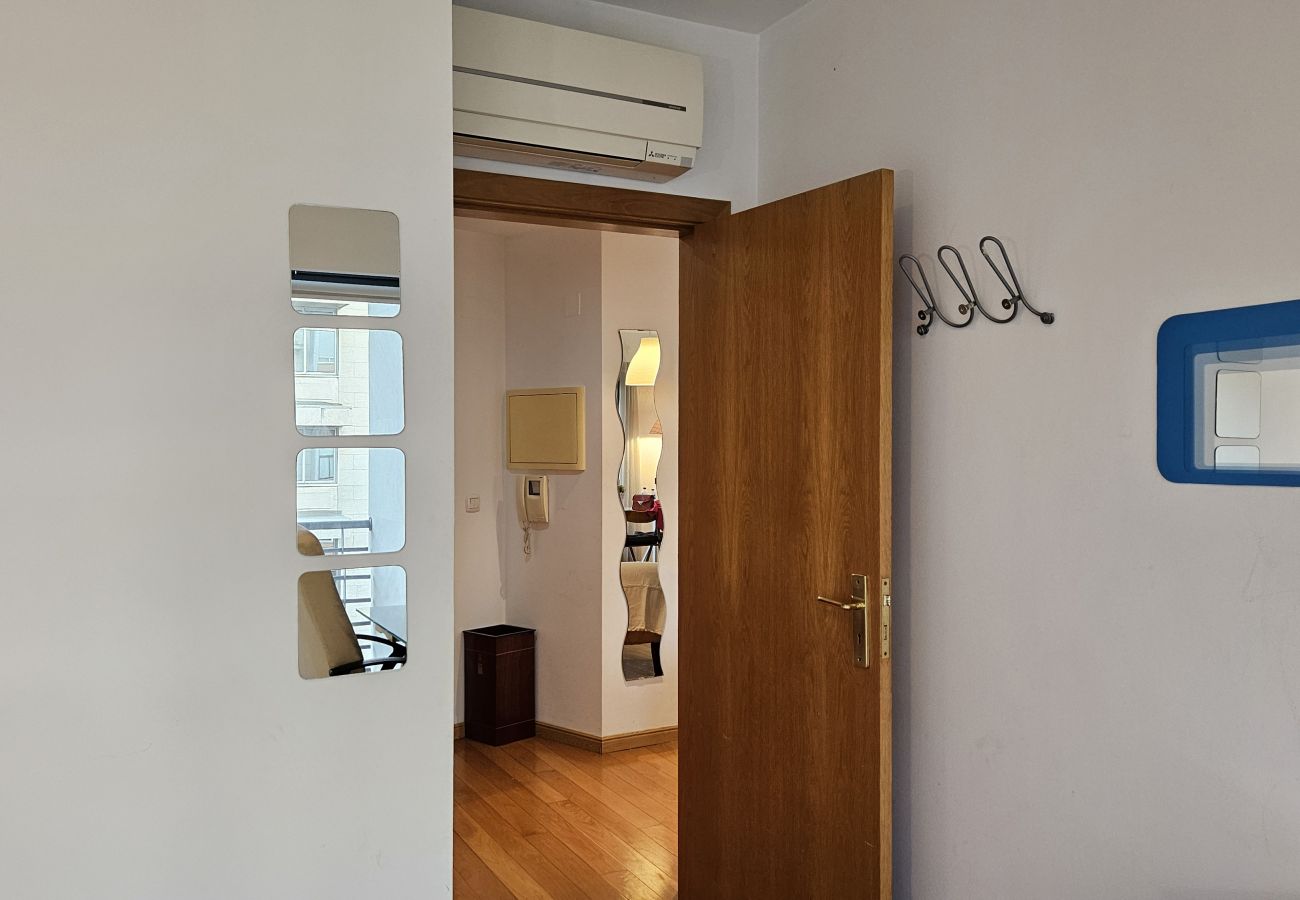 Bedroom entrance with decorative mirrors, white wall, and wooden door.