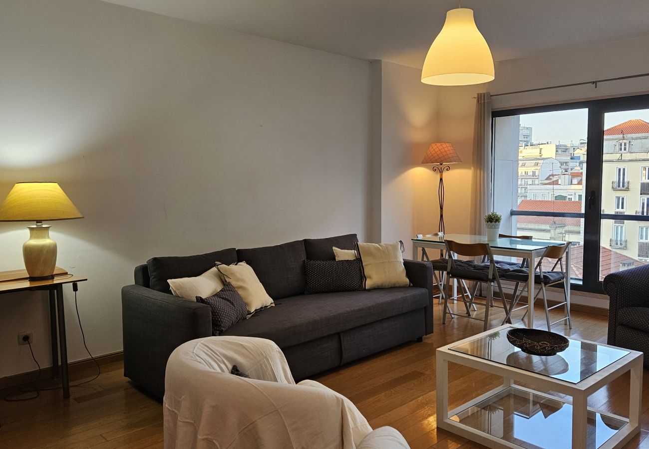 Dining table for four people with large windows and cozy lighting.