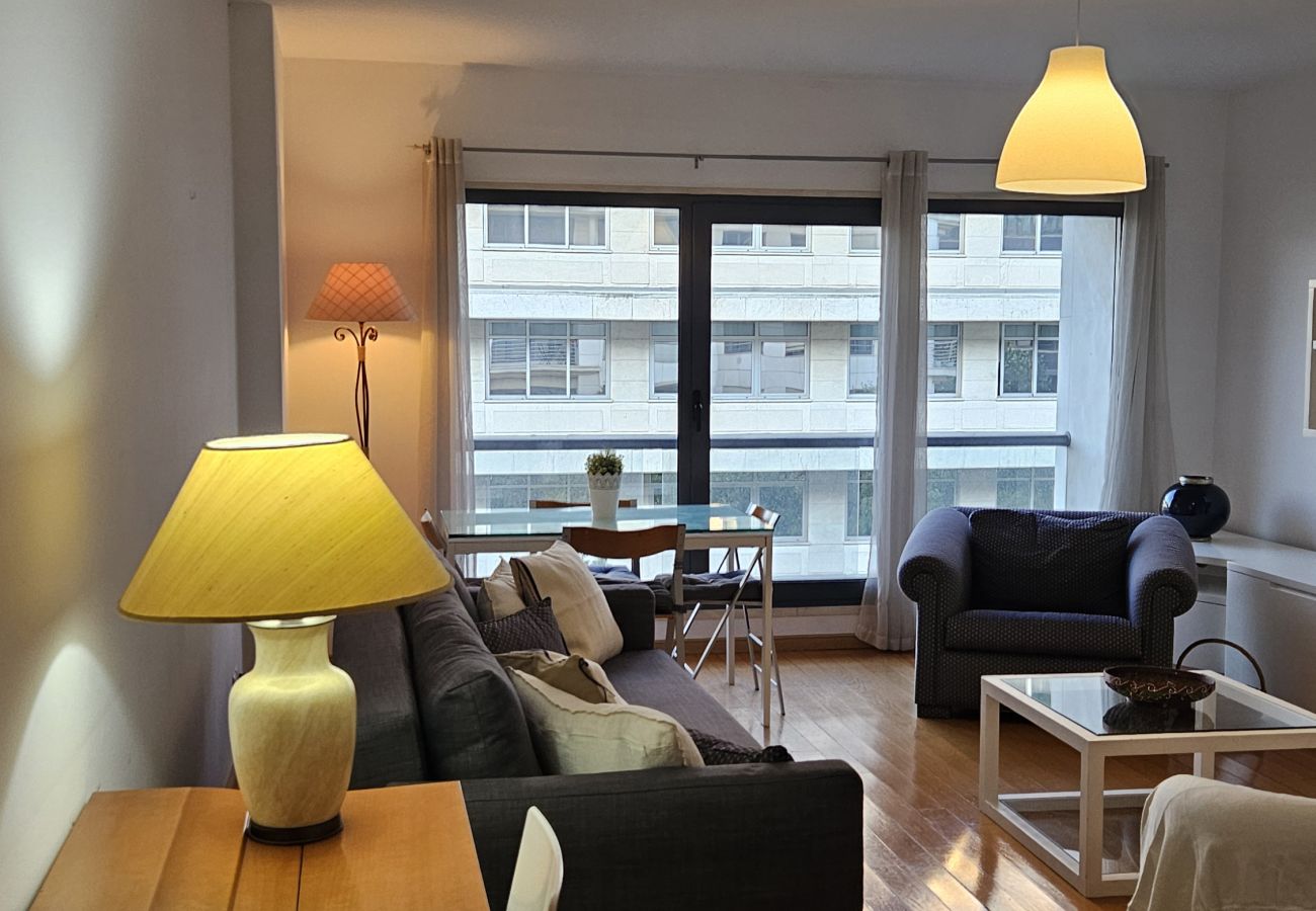 Dining table for four people with large windows and cozy lighting.