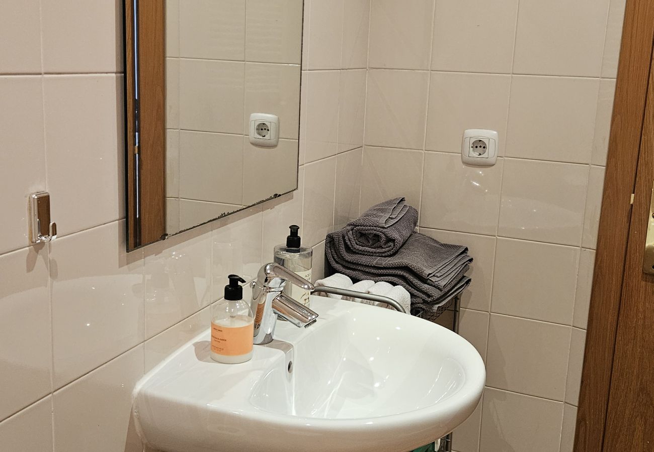 Bathroom with sink, large mirror, organized towels, and modern details.
