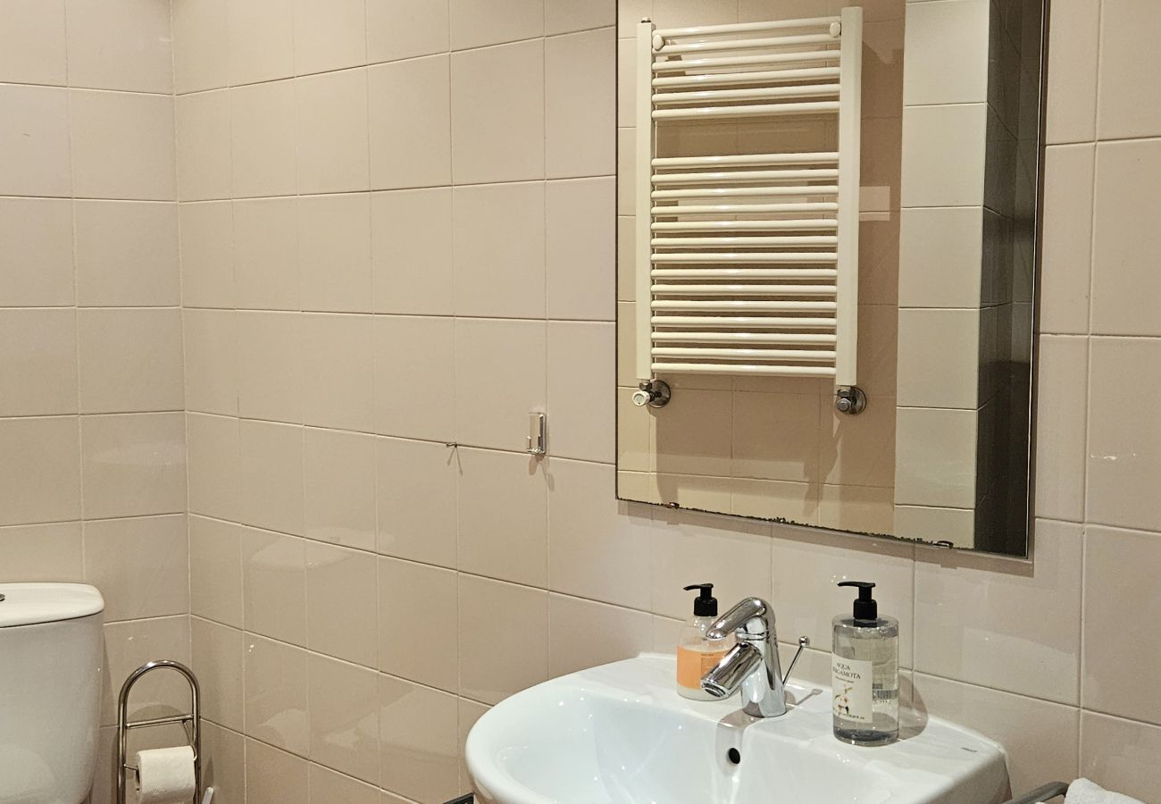 Compact and modern bathroom with a sink and shower.