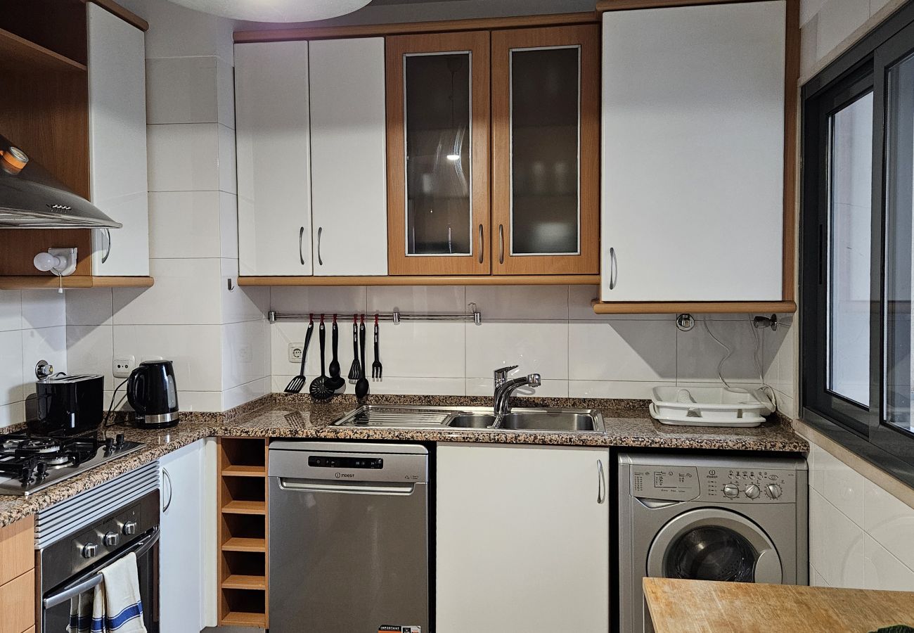 Kitchen with wooden cabinets, modern appliances, and a spacious countertop.