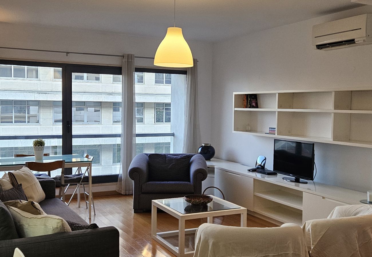 Dining table for four people with large windows and cozy lighting.