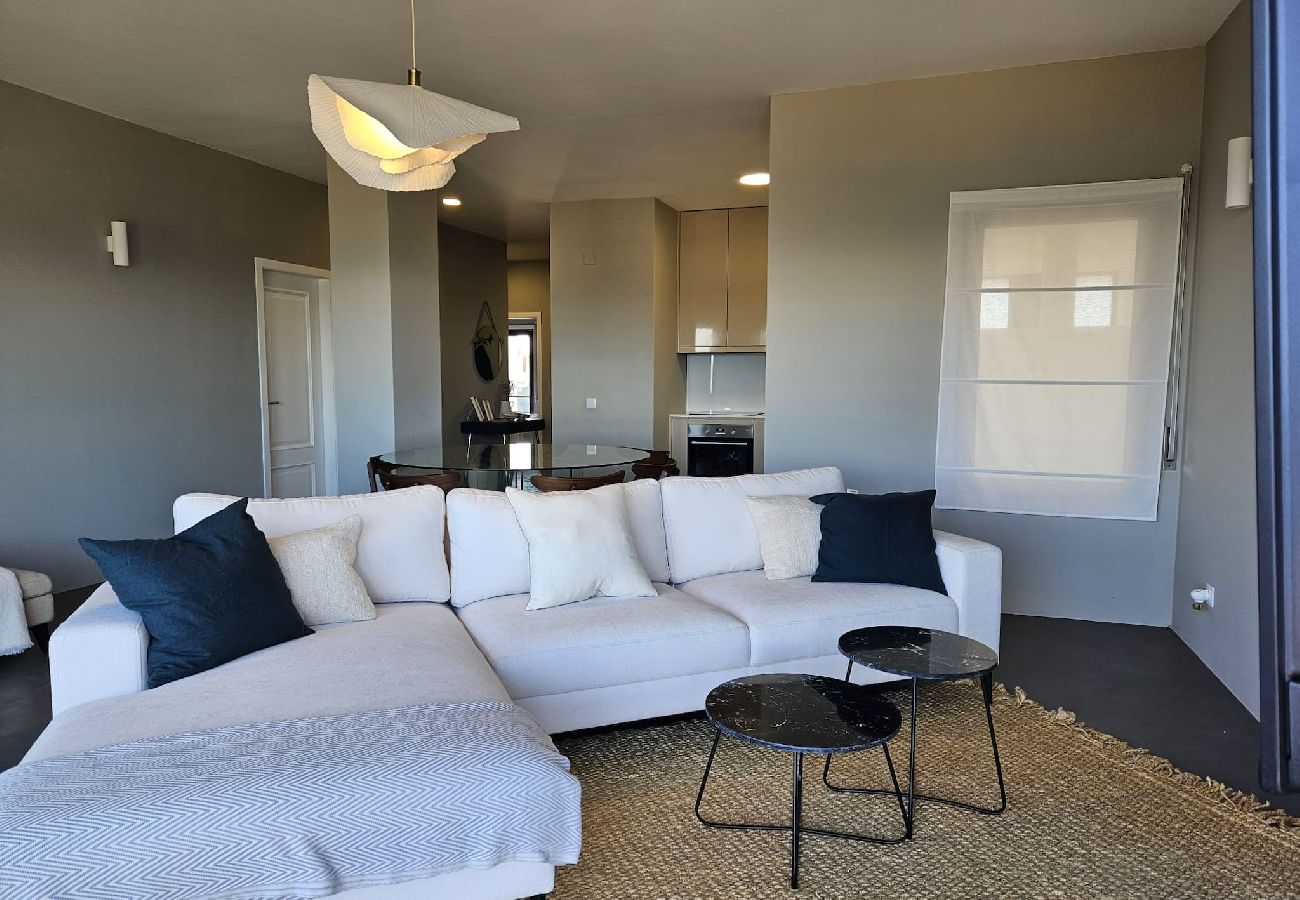 Spacious living room with a large sofa, built-in fireplace, and access to the balcony.