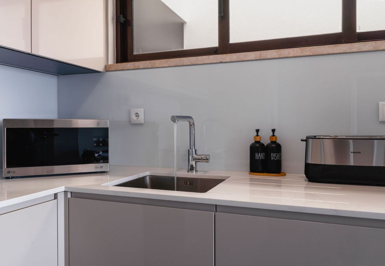 Modern kitchen countertop with stainless steel sink, appliances, and stylish details.