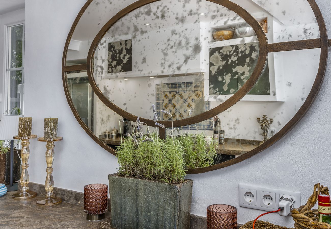  Large mirror with a rustic frame, decorated with plants and artisanal objects.