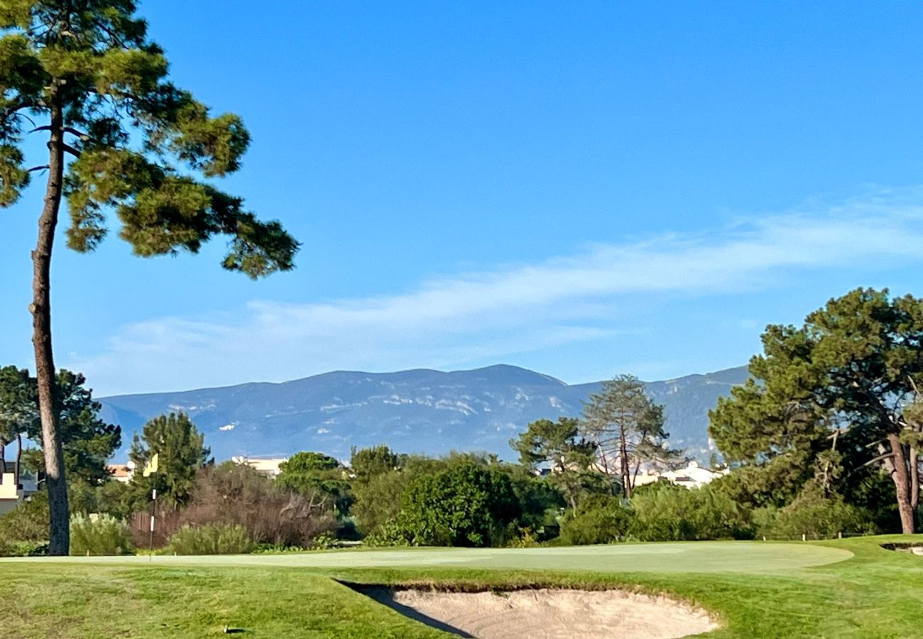 Panoramic view of mountains in the background from the golf course in Troia, with blue sky and natural landscape.