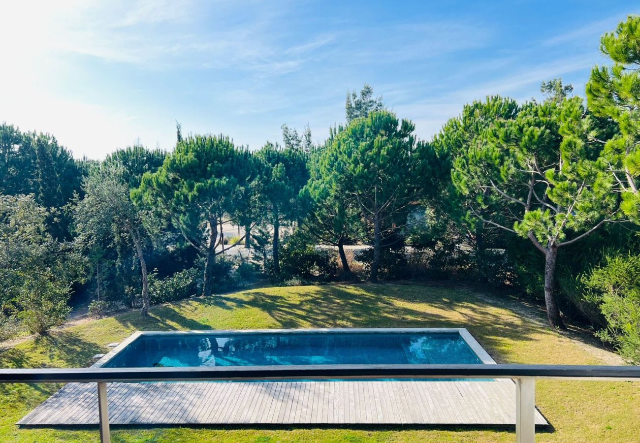 View of the garden with a pool surrounded by trees, providing a peaceful and natural environment.